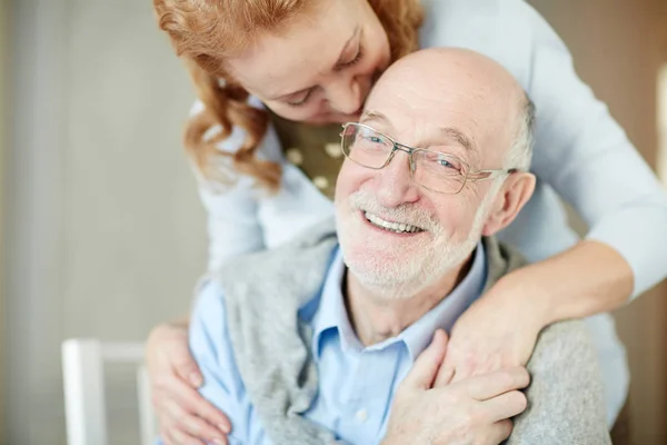 Hombre Sonriente Con Rastrojo Gris Mirando Cámara Mientras Esposa Abraza —  Fotos de Stock