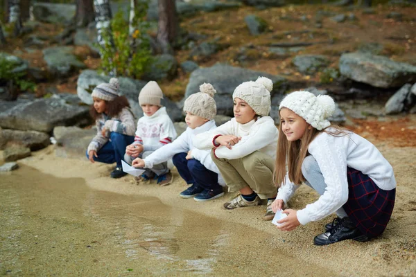 Ряд Детей Сидящих Песке Вдоль Берега — стоковое фото