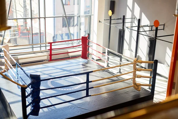 High angle shot of empty boxing ring in sunlit fight club hall