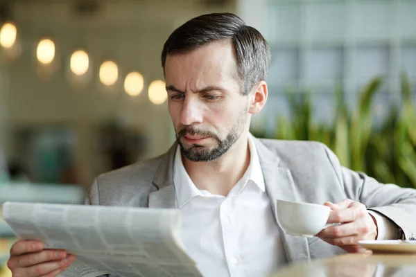 Σοβαρή Και Απασχολημένος Άνθρωπος Φλυτζάνι Του Τσαγιού Διαβάζοντας Ειδήσεις Πρωινού — Φωτογραφία Αρχείου