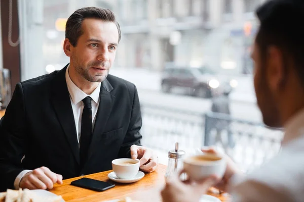 クライアントや同僚のコーヒー カップでカフェでのいずれかに話す銀行 — ストック写真