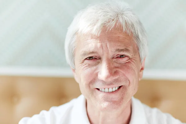 こぼれるような笑顔のカメラ目線で幸せな引退した男の顔 — ストック写真