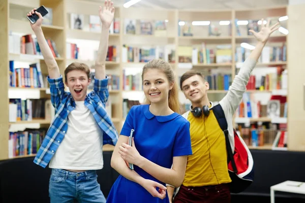 Grupo Tres Estudiantes Felices Sonriendo Alegremente Levantando Las Manos Biblioteca — Foto de Stock