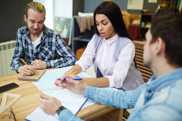 Young people concentrating on work at meeting