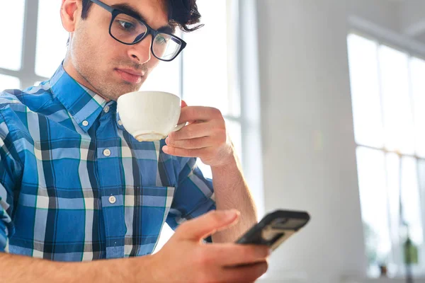 Jonge Man Met Mobiele Telefoon Berichten Met Kopje Koffie — Stockfoto