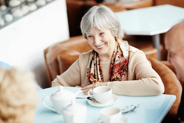 居心地の良い小さな喫茶店に坐っている間彼女の最高の友人と良い時間を過ごして広い笑顔ではかなり年配の女性のウエスト アップ肖像画 — ストック写真