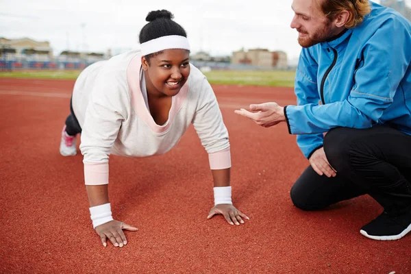 Jonge Trainer Bemoedigend Oversized Vrouwtje Tijdens Training Stadion — Stockfoto