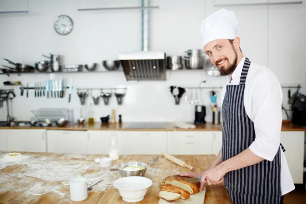 Jonge Bakker Snijden Vers Brood Tafel — Stockfoto