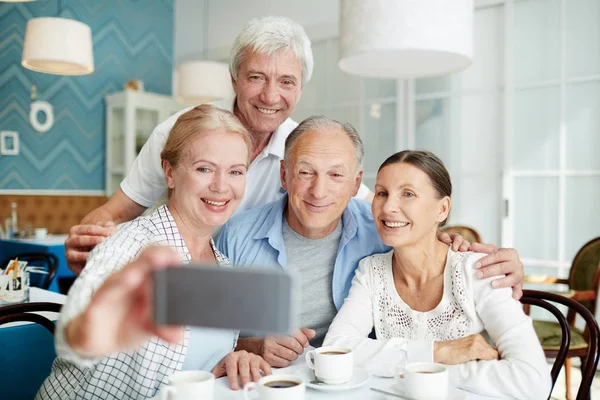 Dos Parejas Mayores Sonrientes Tomando Selfie Teléfono Inteligente Mientras Reúnen —  Fotos de Stock