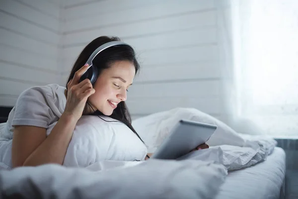 Chica Con Auriculares Touchpad Escuchando Música Cama —  Fotos de Stock