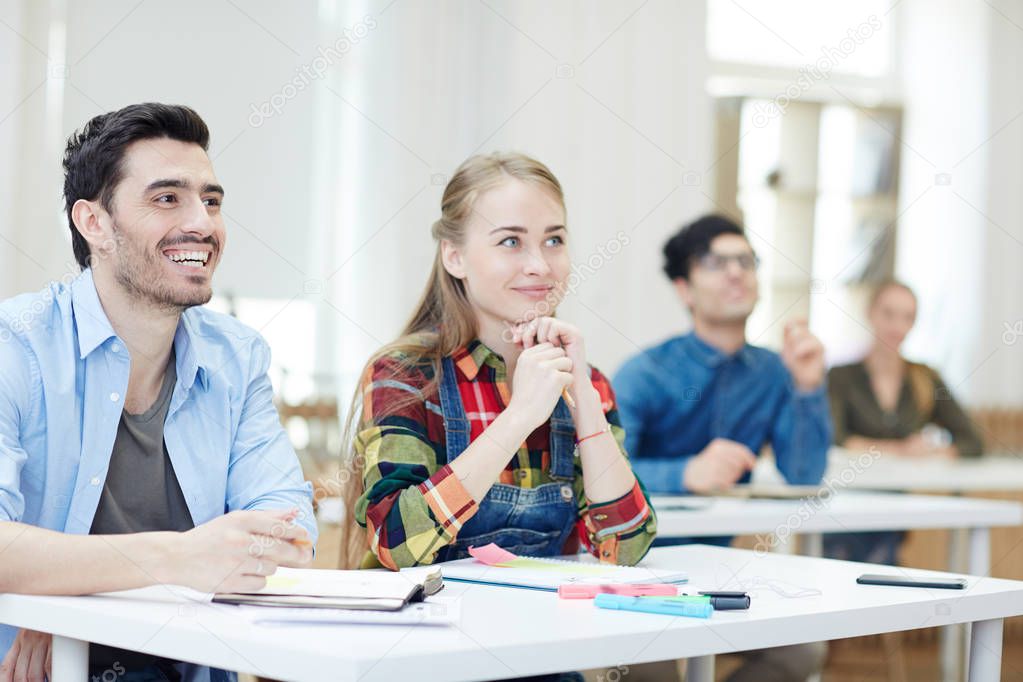 Happy learners listening to teacher at lesson