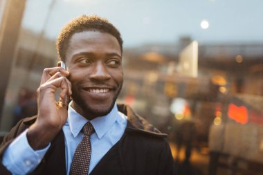 Telefonla konuşurken dişlek gülümseme ile Afrikalı-Amerikalı adam