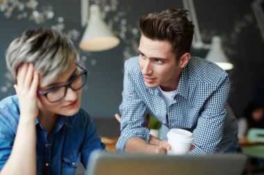 Genç adam için iş arkadaşı konuşurken online veri açıklayan