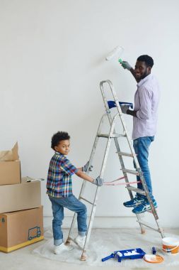 Merdiven ise babası ve boyama duvar üzerinde ayakta tutan çocuk