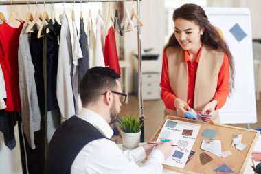Moda tasarımcıları moda renkleri ve kumaş tartışırken danışmanlık