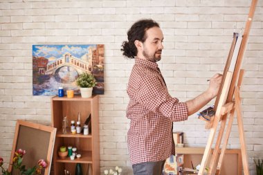 Yan görünümü yetenekli ilham sanatçı resim resim üzerine odaklanmış sanat Studio'da portresi