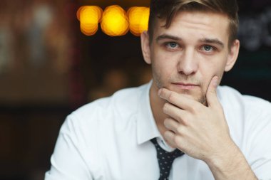 Gömlek ve kravat giyen kameraya bakarak Genç dalgın işadamı portresi Office