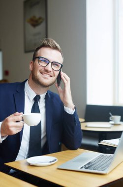 Smartphone sahip kafede içki sırasında konuşan genç satıcısı