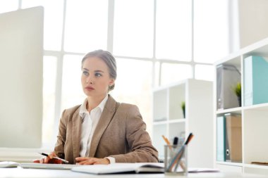 başarılı iş, arka plan üzerinde modern ofis panoramik pencerelere sonuçlarını çözümleme ve bilgisayar başında oturan kadın