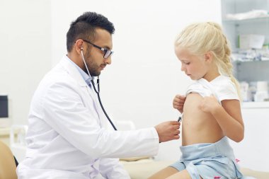 Genç Uygulayıcı stetoskop ile check-up biraz sabırlı yapıyor