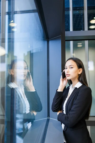 Atrakcyjna Kobieta Patrząc Kamery Stojąc Przy Oknie Office Rozmowy Telefon — Zdjęcie stockowe