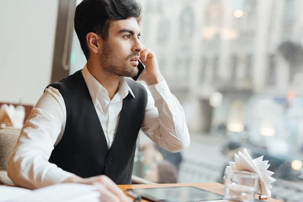 Ung Erhvervsdrivende Sidder Cafe Taler Med Nogen Mobiltelefon - Stock-foto