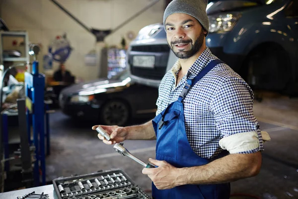 Modern mechanic with hand-tool in garage