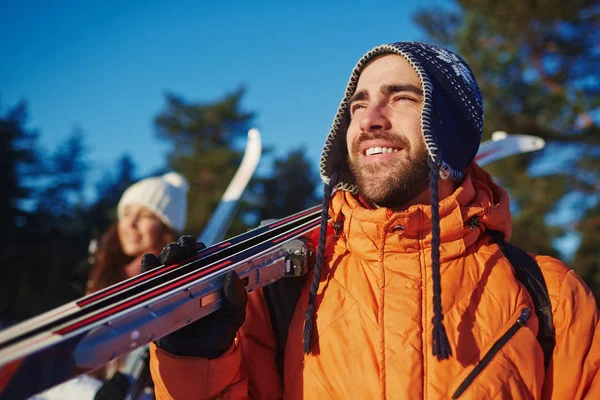 Glimlachende Man Met Ski Zijn Vrouw Zoek Naar Iets Nieuwsgierig — Stockfoto