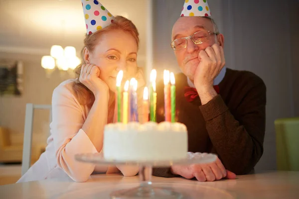 幸福的配偶看着生日蛋糕上燃烧的蜡烛 — 图库照片
