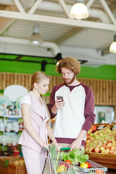 Casal Moderno Olhando Através Nova Promo Smartphone Supermercado — Fotografia de Stock