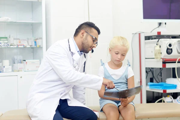 Mała Dziewczynka Ogląda Zdjęcie Rentgenowskie Podczas Gdy Lekarz Tłumacząc — Zdjęcie stockowe