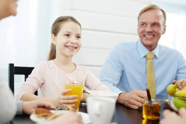 微笑的女孩和她的父亲坐在餐桌旁吃早饭 — 图库照片