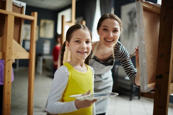 若い教師と学習者水彩画アート スタジオでイーゼルのそばに立って — ストック写真