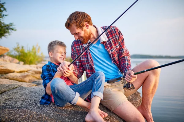 Retrato Padre Guapo Juguetón Cosquillas Hijo Sentado Roca Por Lago —  Fotos de Stock