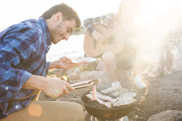 若い男が焙煎し レジャーで友達とピクニックの間のグリル ステーキ — ストック写真