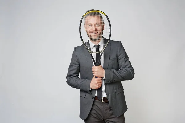 Ler Mitten Åldern Affärsman Tittar Kameran Genom Tennisracket Mot Grå — Stockfoto