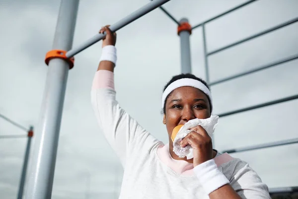 Mujer Africana Regordeta Comiendo Hamburguesa Malsana Mientras Practica Ejercicio Pull —  Fotos de Stock