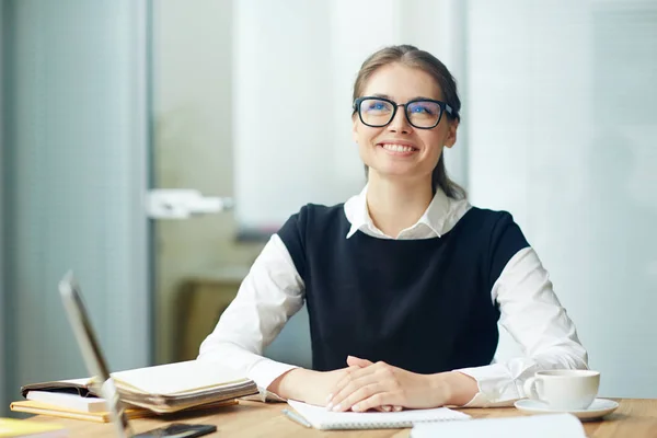 Joven Mujer Negocios Sonriente Con Anteojos Sentada Junto Lugar Trabajo — Foto de Stock