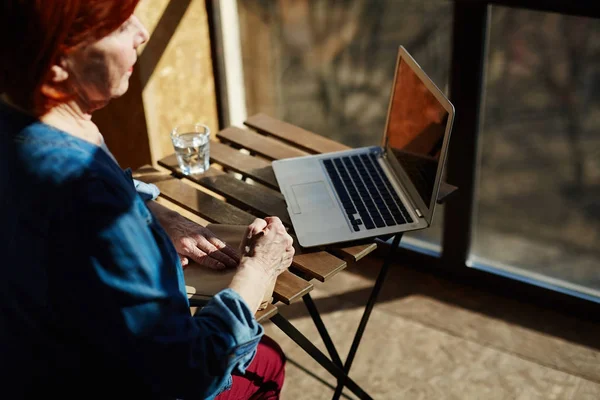 Zamyślony Starszy Kobieta Siedzi Przez Tabela Laptopa Nim — Zdjęcie stockowe