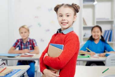 Kırmızı kazaklı fotoğraf makinesi vasıl sınıf arkadaşlarından arka plan üzerinde seyir tatlı kız öğrenci