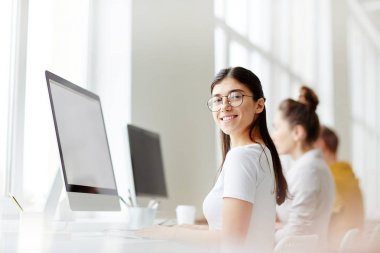 Beyaz tişört ve eğitim sürecinde kameraya bakarak gözlük başarılı genç öğrenci