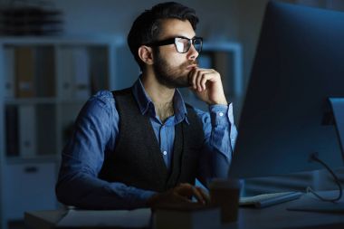 Konsantre girişimci veya geceleri çalışırken önünde bilgisayar monitörü Masası tarafından oturan Yöneticisi