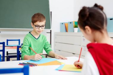Küçük secontary schoolkids sınıf gazetelerde çizim boya kalemi ile