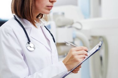 Kalem ve iş yerinde tıbbi notlar yapma pano ile genç klinisyen