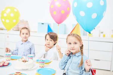 Şirin çocuklarla renkli balonlar doğum günü partisi anaokulunda tadını çıkarırken kameraya bakıyor