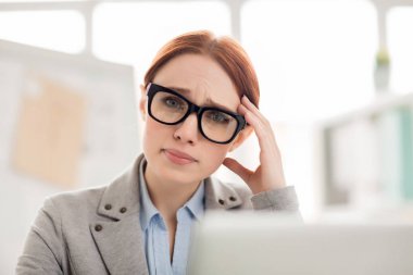 Genç kadın kamera çalışması sırasında düşünürken bakarak sorunlu