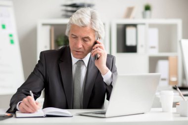 Kendine güvenen yönetmen tarafından Smartphone notlar işyeri tarafından yaparken konuşma