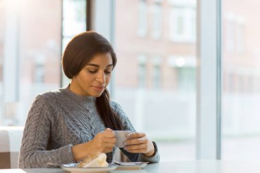 Güzel kız lezzetli tatlı ve sıcak aromatik kahve kafede dinlenirken sahip