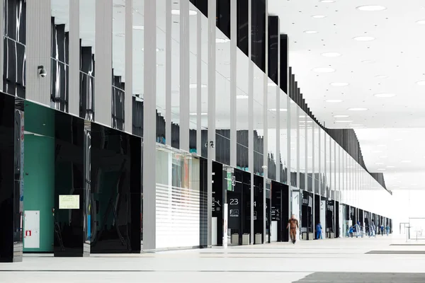 Interior of modern airport with humans walking and working along