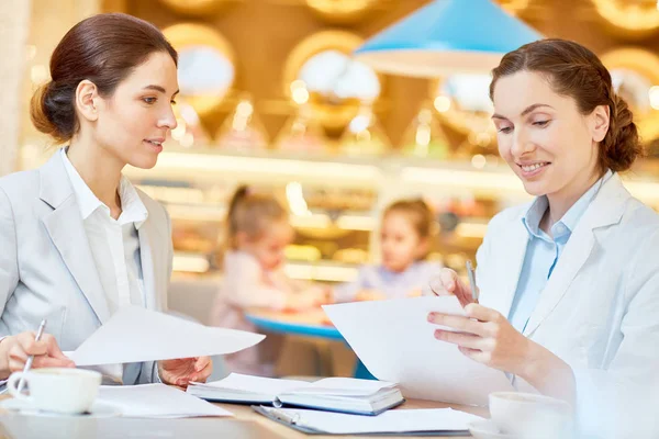 Dos Empleados Ocupados Discutiendo Documentos Negocios Cafetería Mientras Sus Hijas —  Fotos de Stock